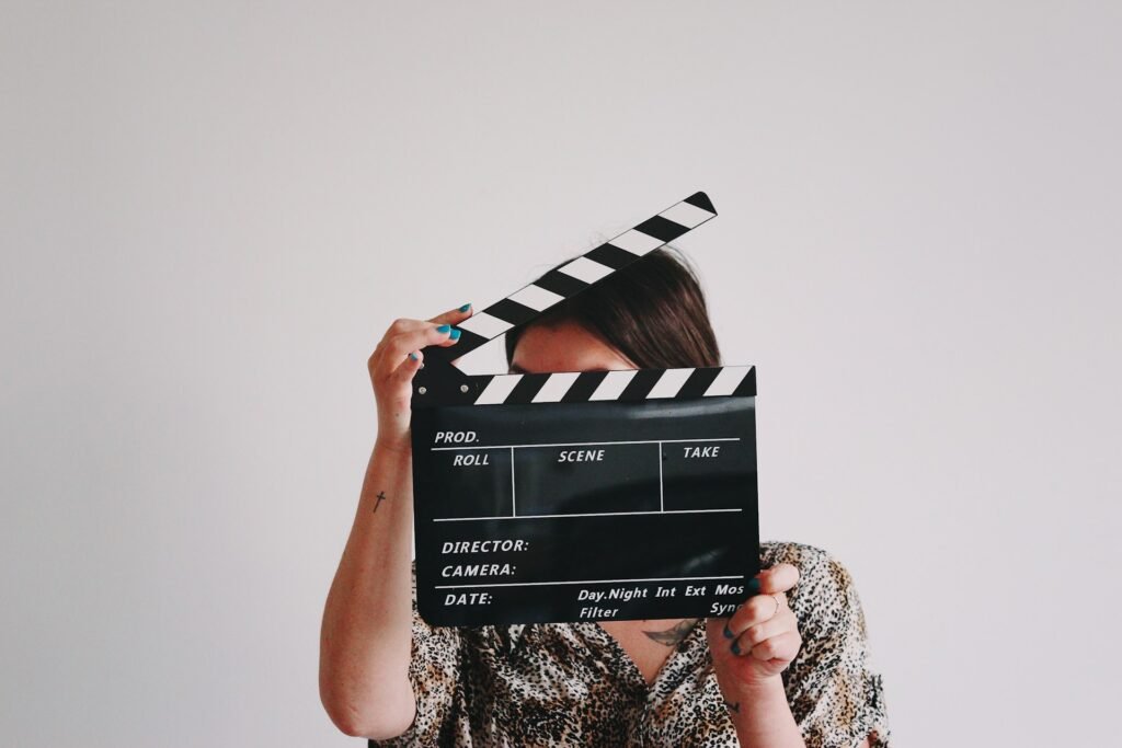 a-woman-holding-a-clapper-over-her-face