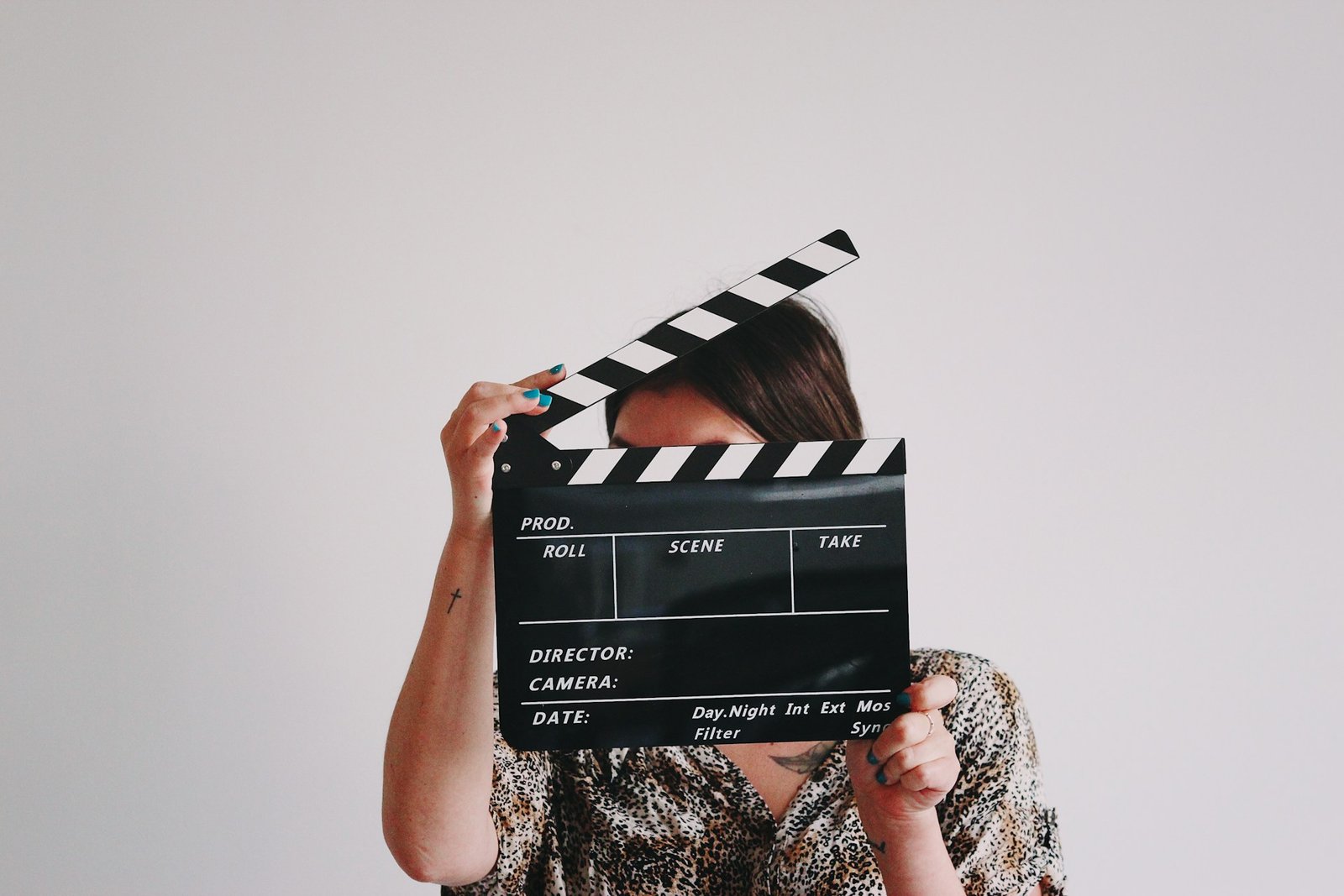a-woman-holding-a-clapper-over-her-face